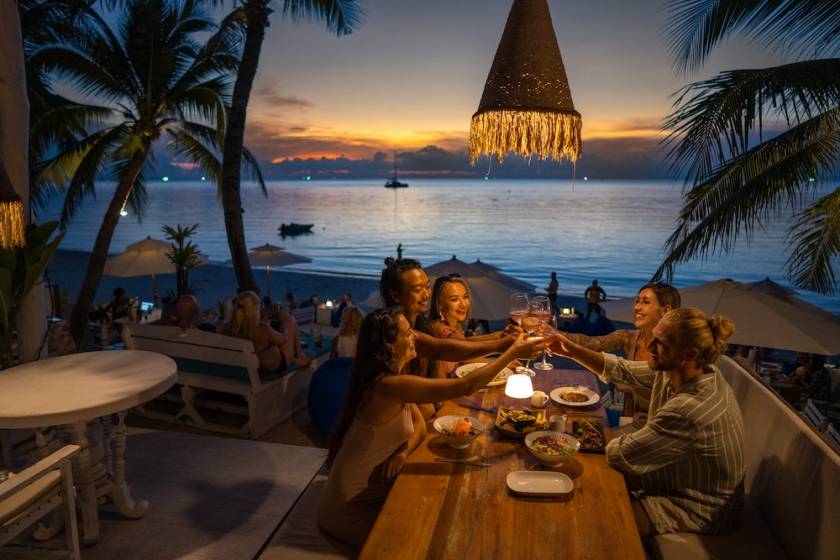 Friends at dinner in beach town at dusk